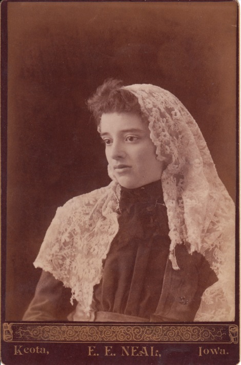 The woman is wearing a large lace veil or kerchief